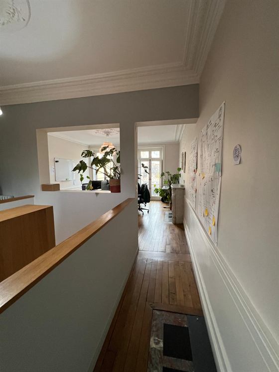 Couloir de l'étage avec parquet ancien, moulures et vue sur un bureau