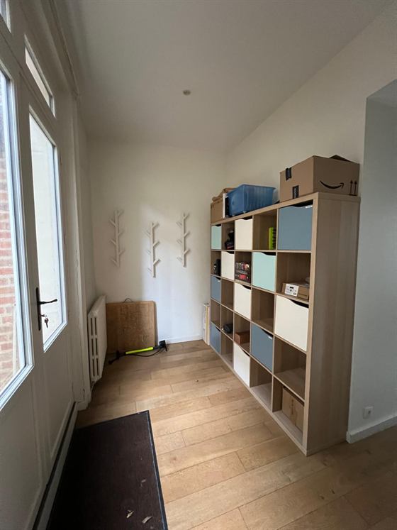 Entrée avec patères, meuble à casiers et accès sur la cour