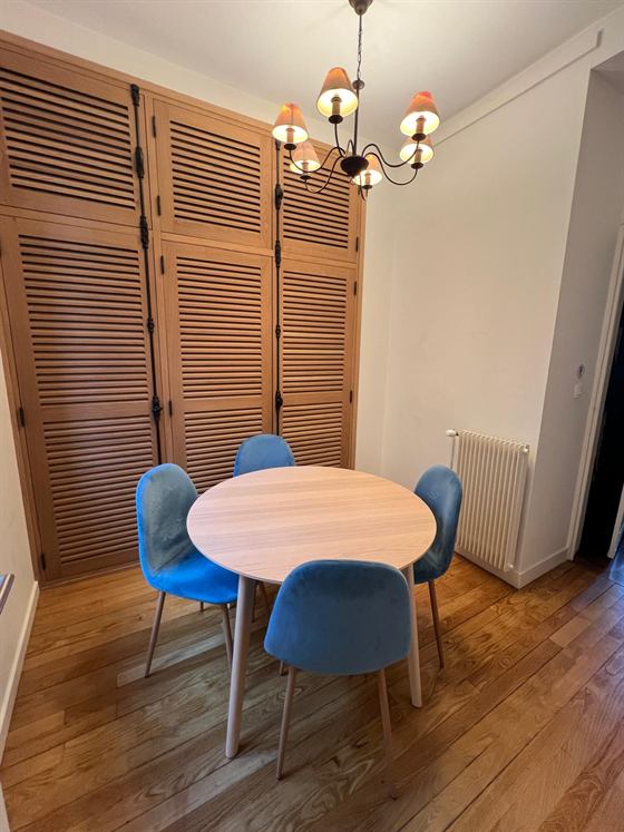 Petite salle de réunion avec table ronde et quatre chaises bleues